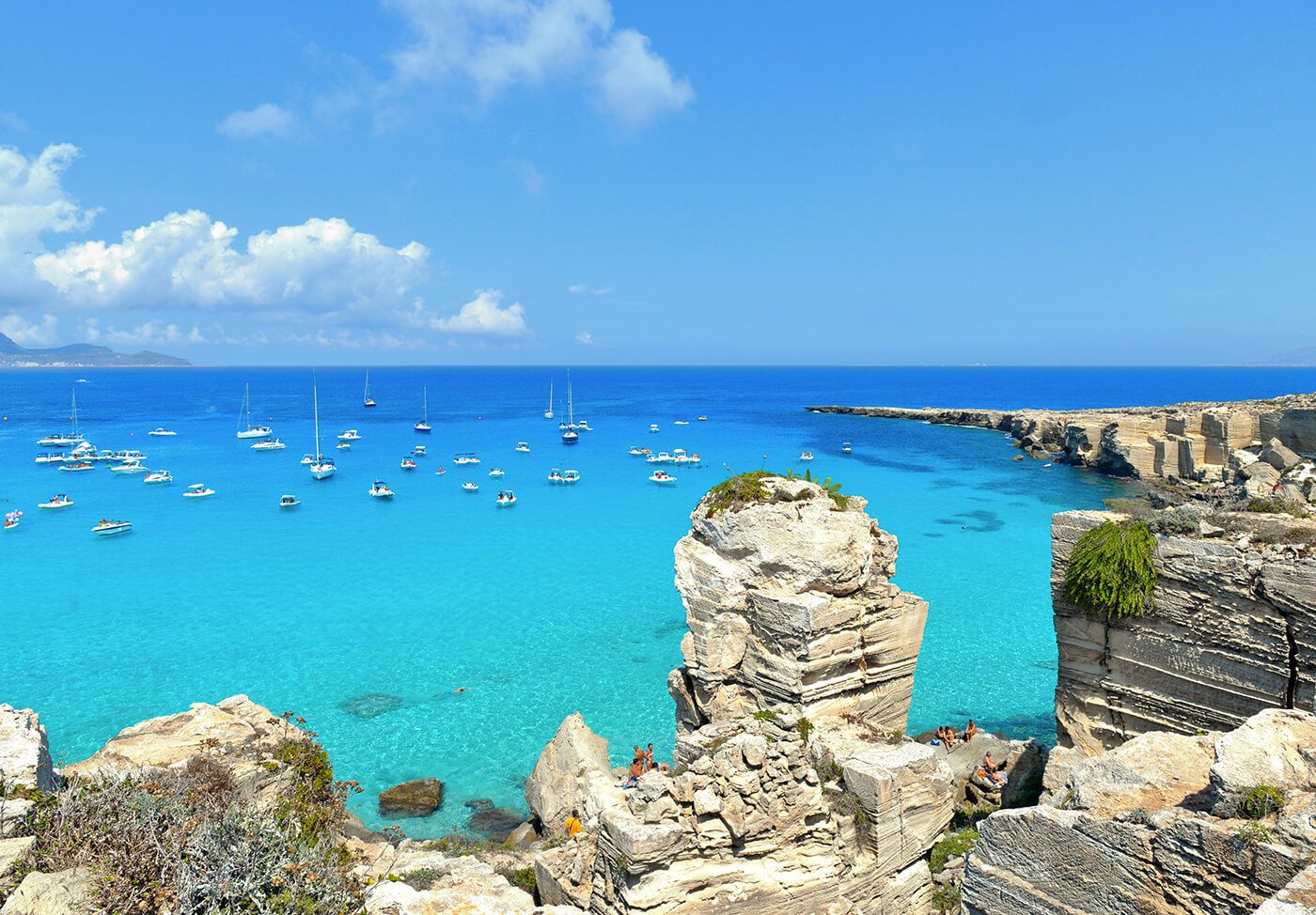 L'acqua turchese di Cala Rossa con il faraglione di tufo